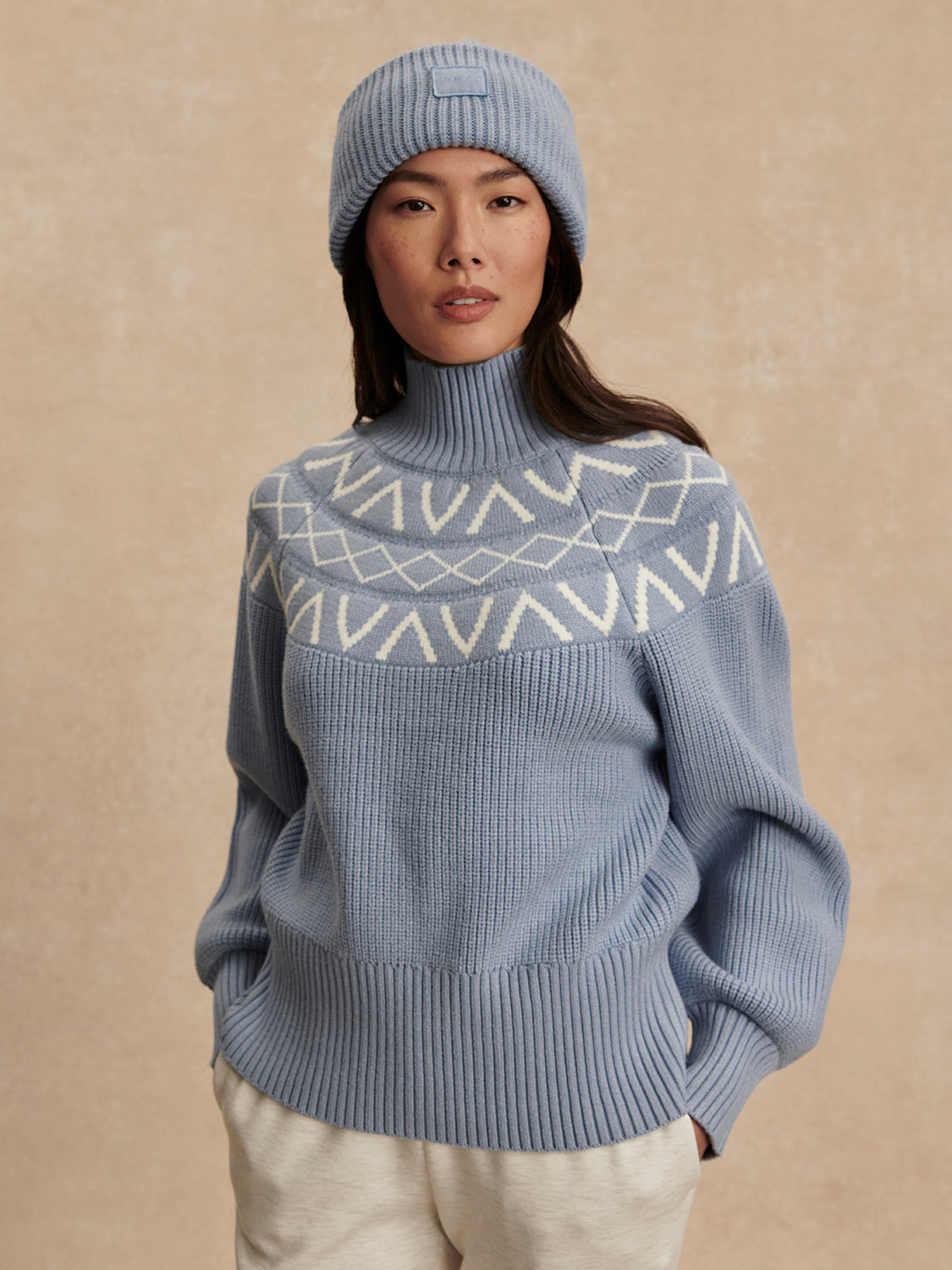blue ribbed jumper with white varley logo and high neck