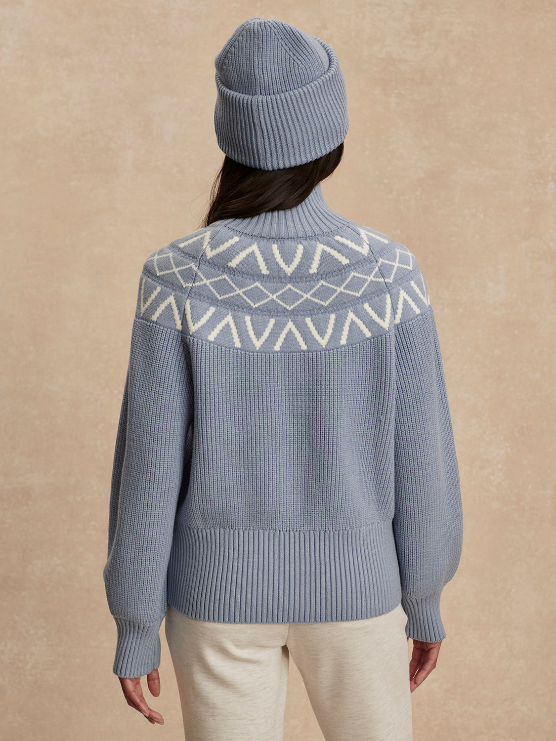 blue ribbed jumper with white varley logo and high neck rear view