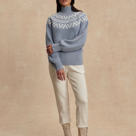 blue ribbed jumper with white varley logo and high neck model shot