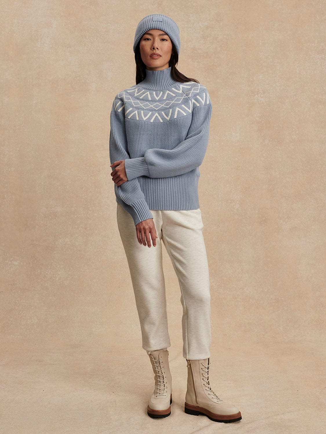 blue ribbed jumper with white varley logo and high neck model shot