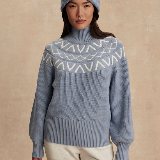 blue ribbed jumper with white varley logo and high neck model shot