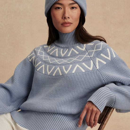 blue ribbed jumper with white varley logo and high neck model shot