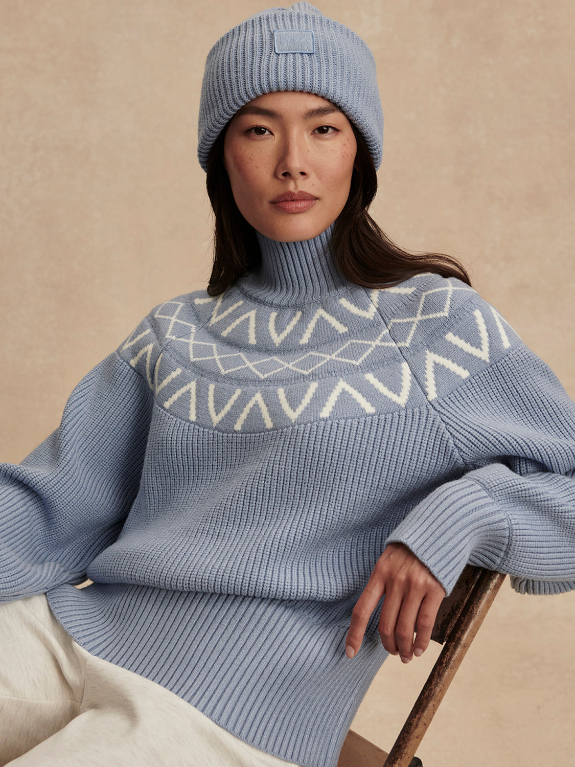 blue ribbed jumper with white varley logo and high neck model shot