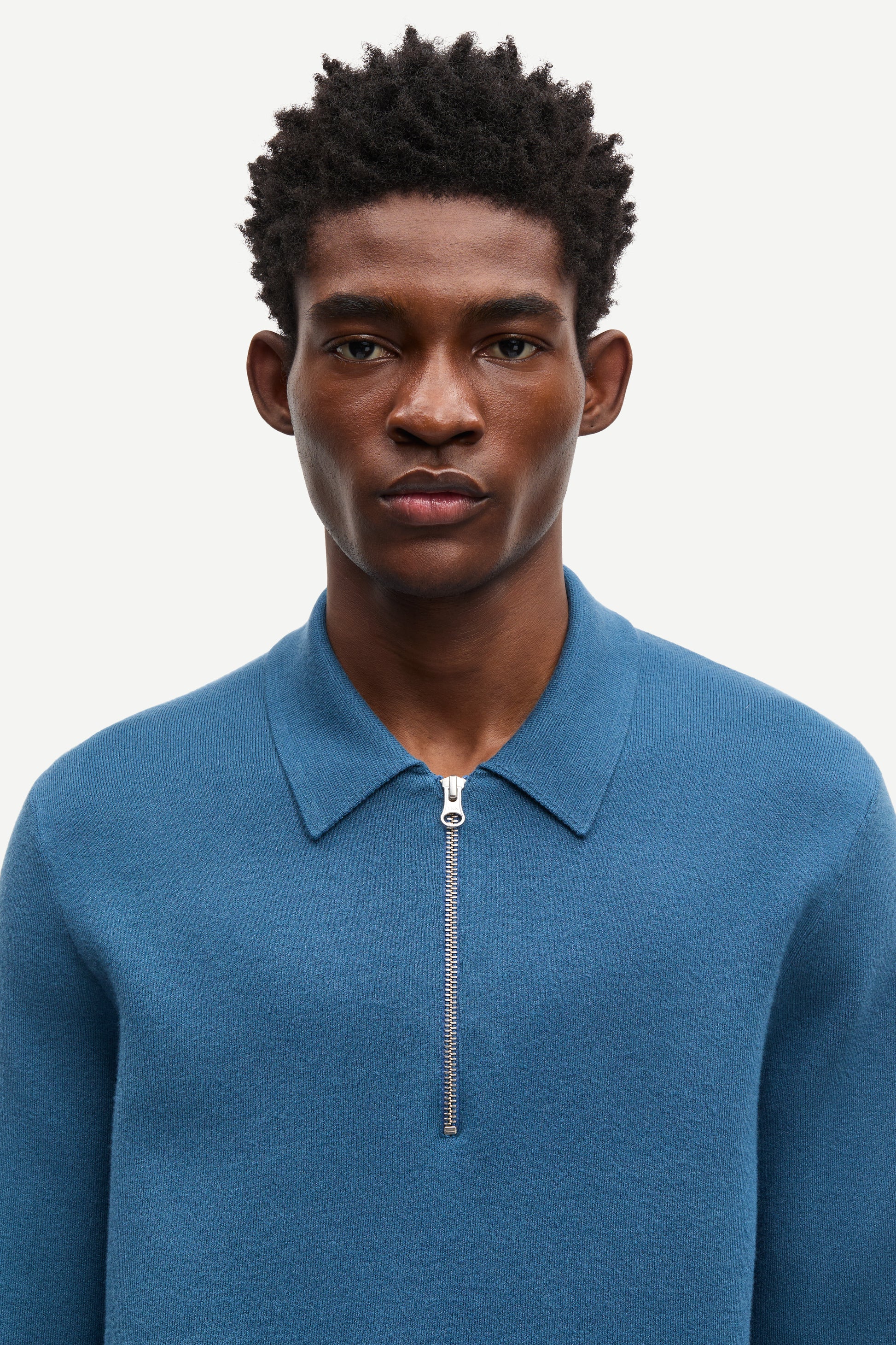 Blue long-sleeve polo shirt with a half zipped placket and relaxed fit close up