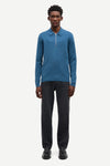 Blue long-sleeve polo shirt with a half zipped placket and relaxed fit model shot