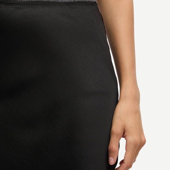 long satin black skirt with elasticated waistband and cut on the bias close up