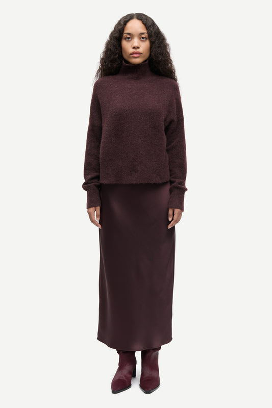Woman wearing a burgundy brown sweater and skirt set on a white background from Samsoe Samsoe