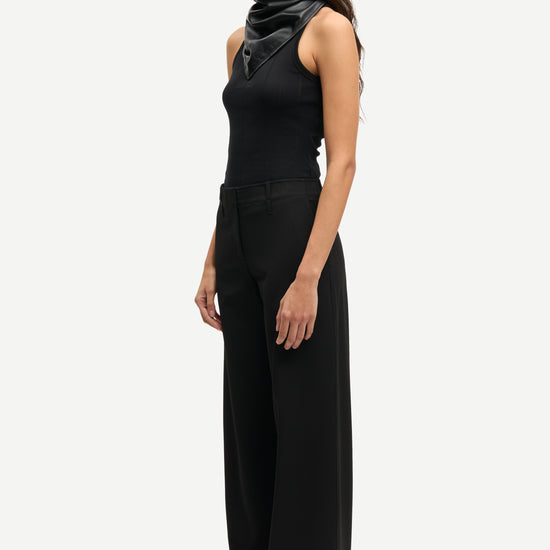 Side view of black trousers worn with black vest tee