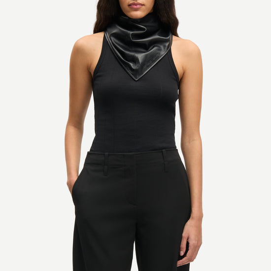 Front view of black tailored Samsoe Samsoe trousers worn with black vest tee