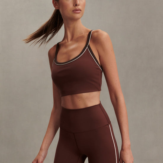 brown sports bra with white piping form varley model shot