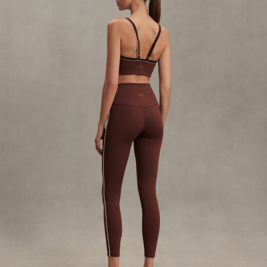 brown sports bra with white piping form varley rear view model 