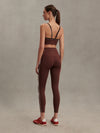 brown sports bra with white piping form varley rear view model 