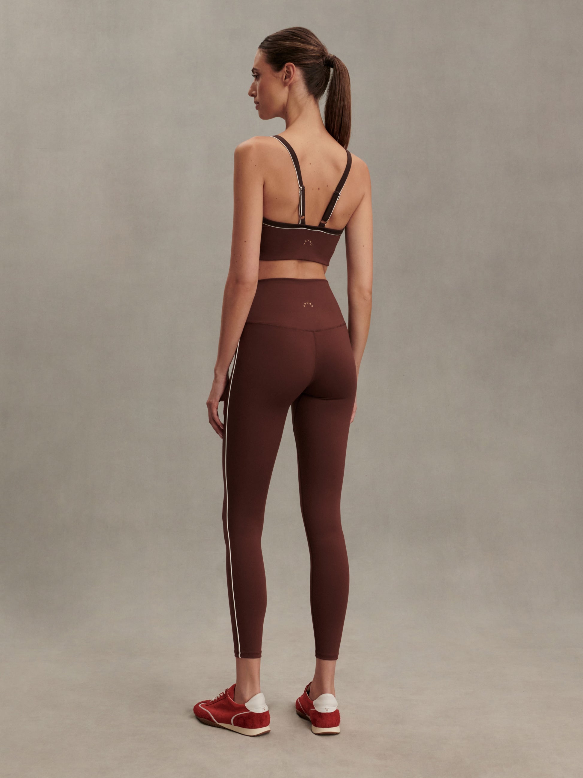 brown sports bra with white piping form varley rear view model 