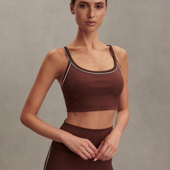 brown sports bra with white piping form varley model shot