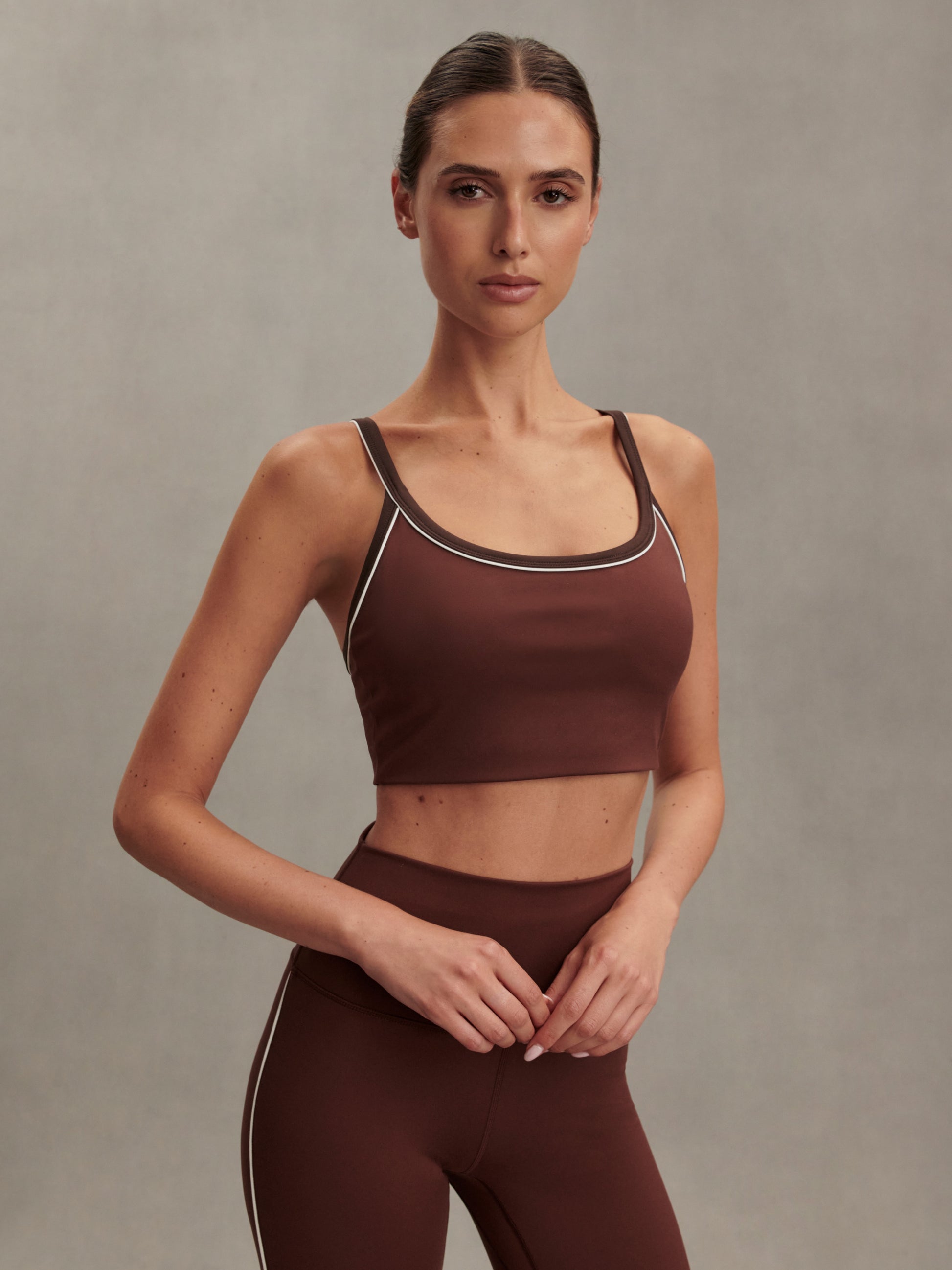 brown sports bra with white piping form varley model shot