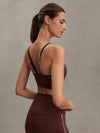brown sports bra with white piping form varley model rear view