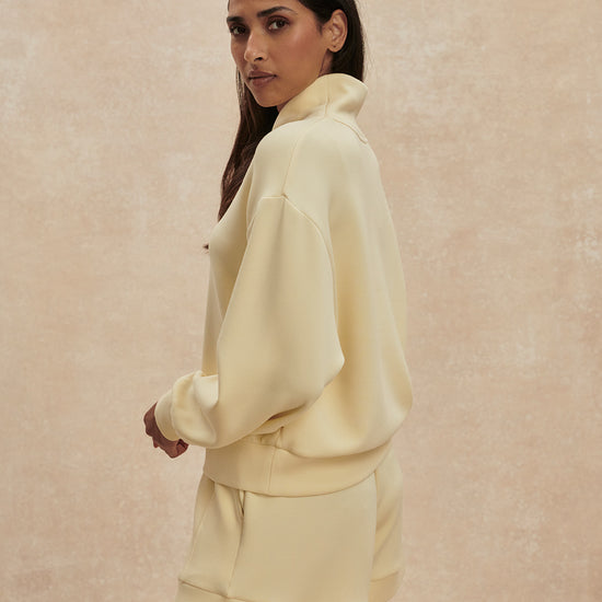 pale yellow jumper with half zip from varley side view