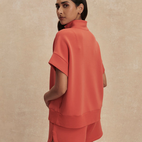 short sleeve coral half zip sweatshirt with high neck from varley rear view