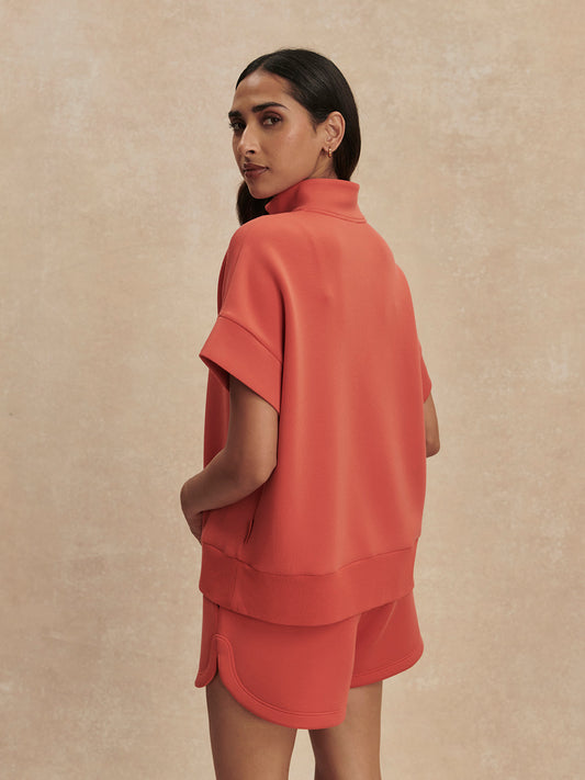 short sleeve coral half zip sweatshirt with high neck from varley rear view