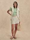 ivory chino style tailored shorts with double buttons and pleat detailing from varley model shot