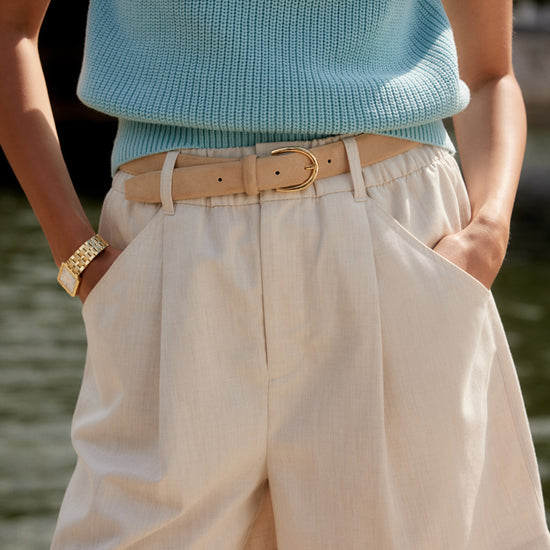 ivory chino style tailored shorts with double buttons and pleat detailing from varley model shot