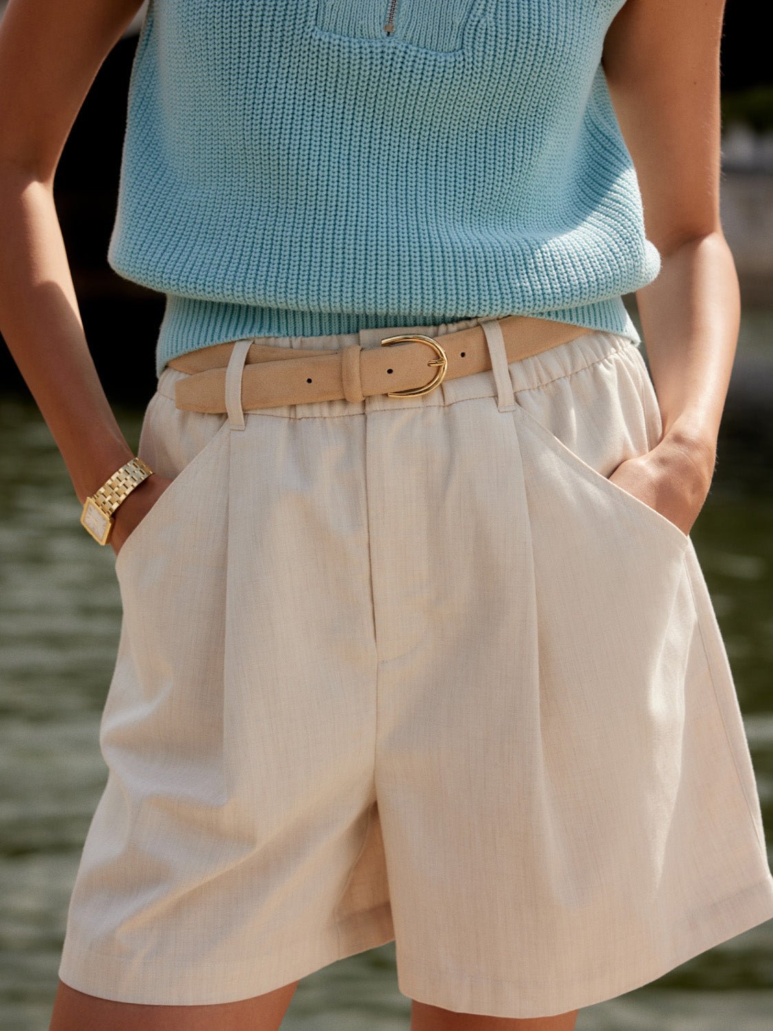 ivory chino style tailored shorts with double buttons and pleat detailing from varley model shot