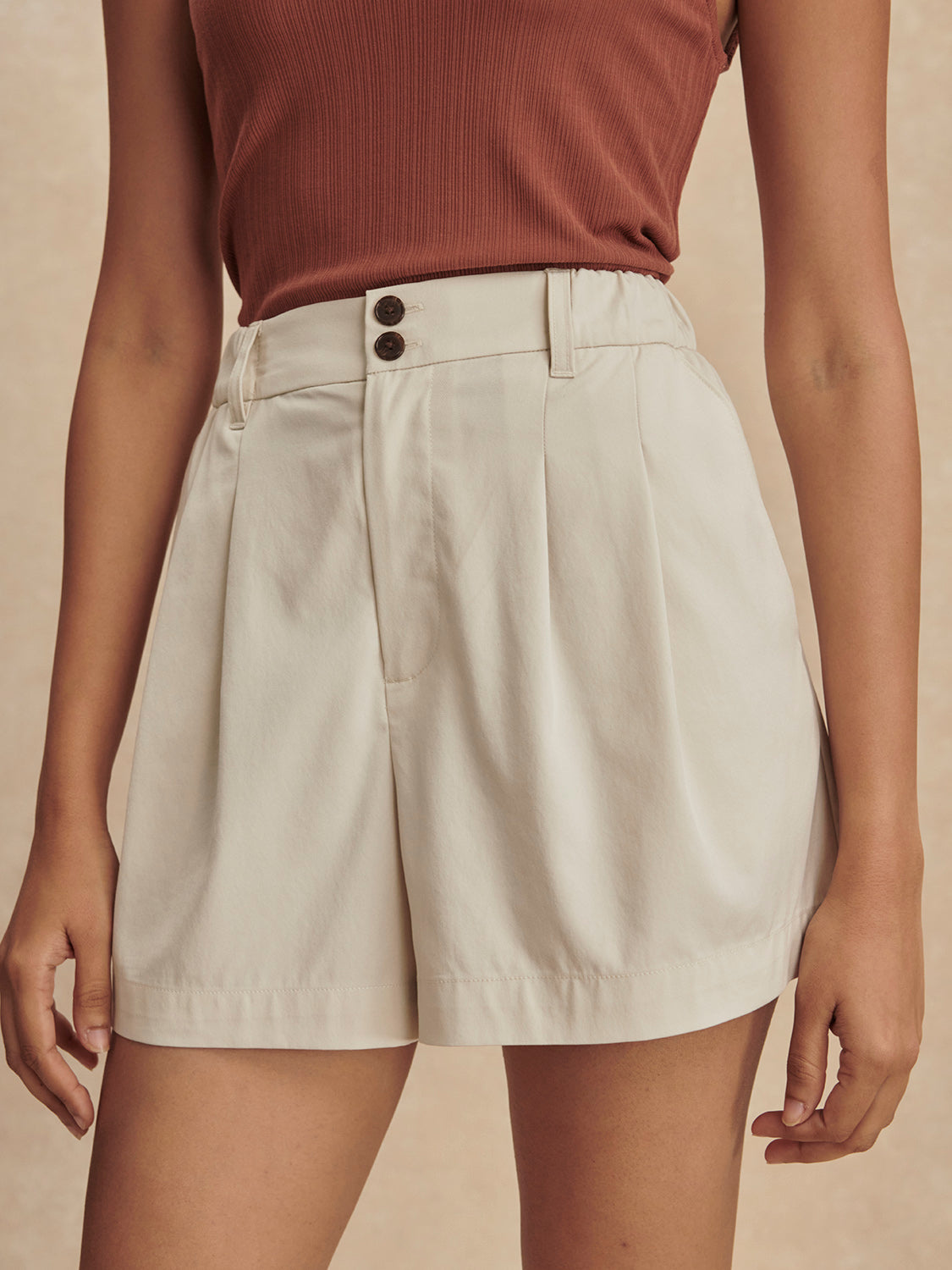 ivory chino style tailored shorts with double buttons and pleat detailing from varley model shot