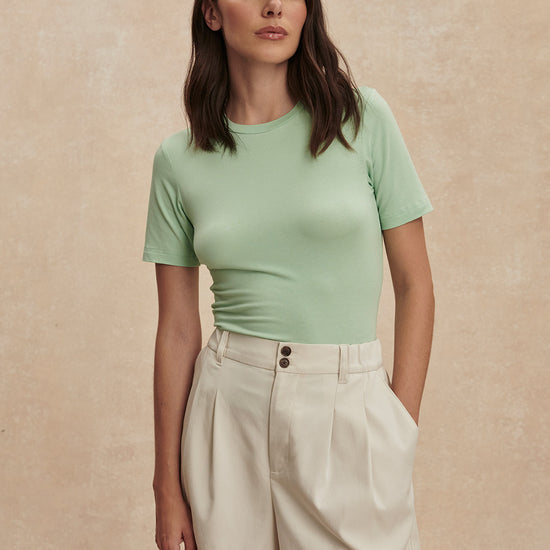 ivory chino style tailored shorts with double buttons and pleat detailing from varley model shot
