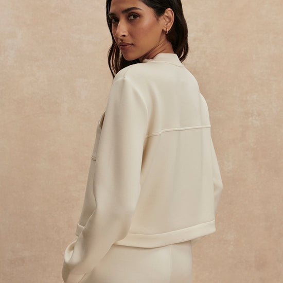 round neck soft sweat jacket with 2 flap pockets and large cream buttons from varley rear view