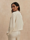 round neck soft sweat jacket with 2 flap pockets and large cream buttons from varley rear view