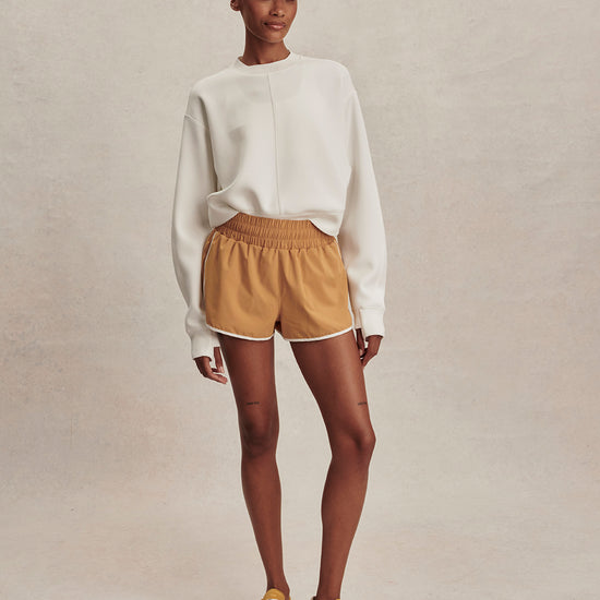 round neck ivory sweatshirt with piping down the centre from varley model shot