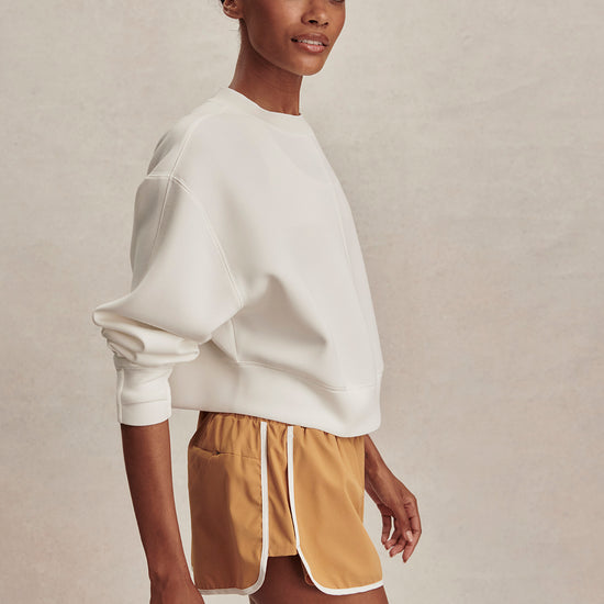 round neck ivory sweatshirt with piping down the centre from varley side view