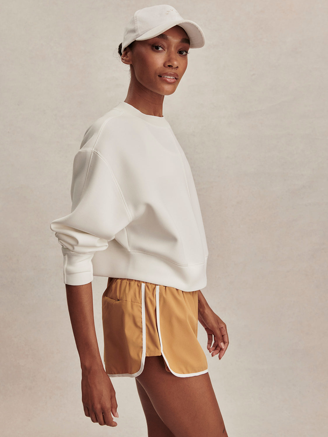 round neck ivory sweatshirt with piping down the centre from varley side view