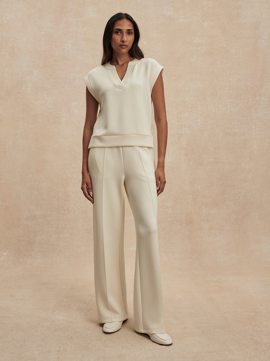 wide leg ivory sweat pants with central piping seam and elasticated waist from varley model shot