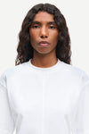 Person wearing a plain white shirt against a light background from Samsoe Samsoe