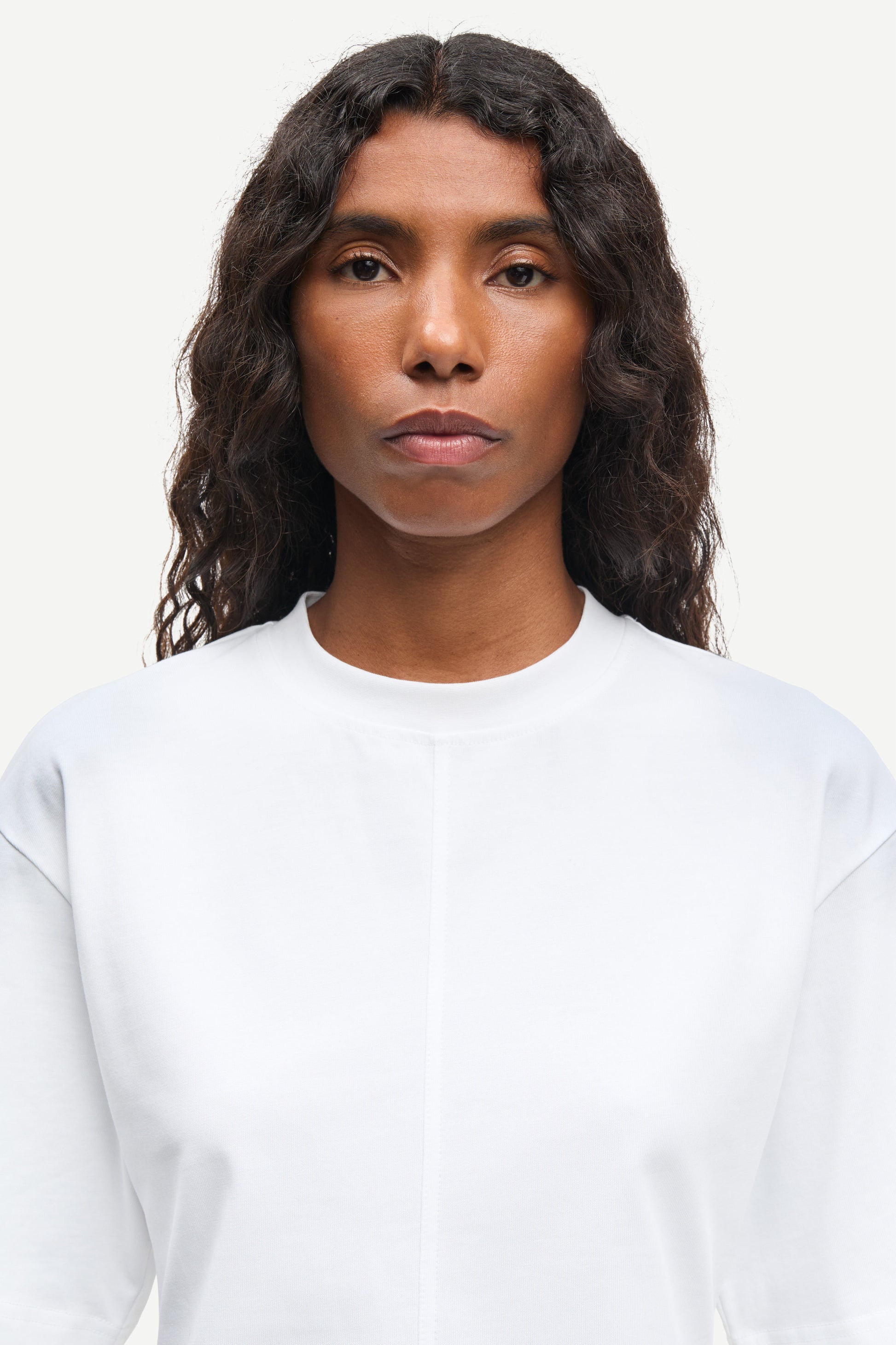 Person wearing a plain white shirt against a light background from Samsoe Samsoe