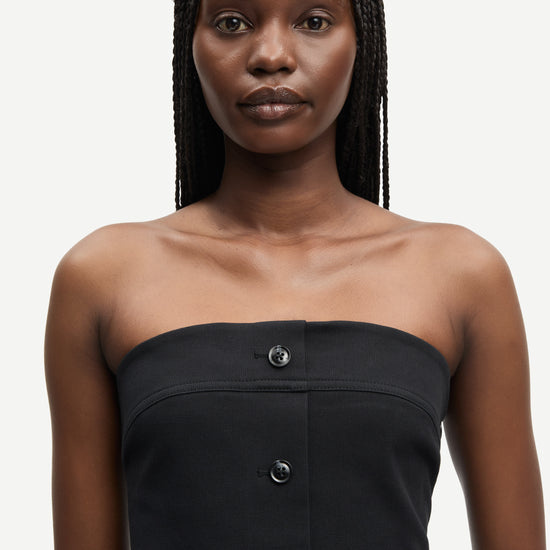 strapless mid length black dress with button down and a line shape from samsoe close up