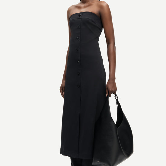 strapless mid length black dress with button down and a line shape from samsoe side view