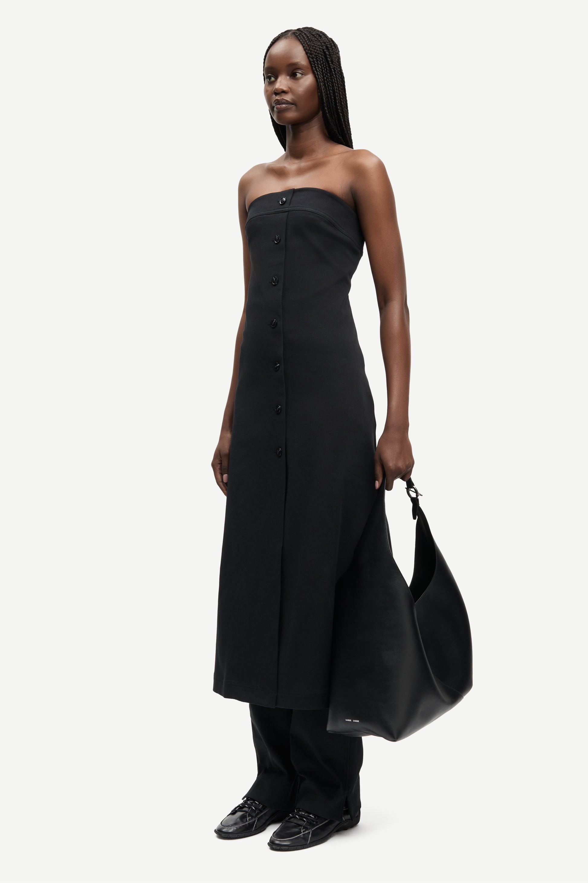 strapless mid length black dress with button down and a line shape from samsoe side view