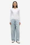Person wearing white long sleeve tee  with blue jeans from Samsoe Samsoe