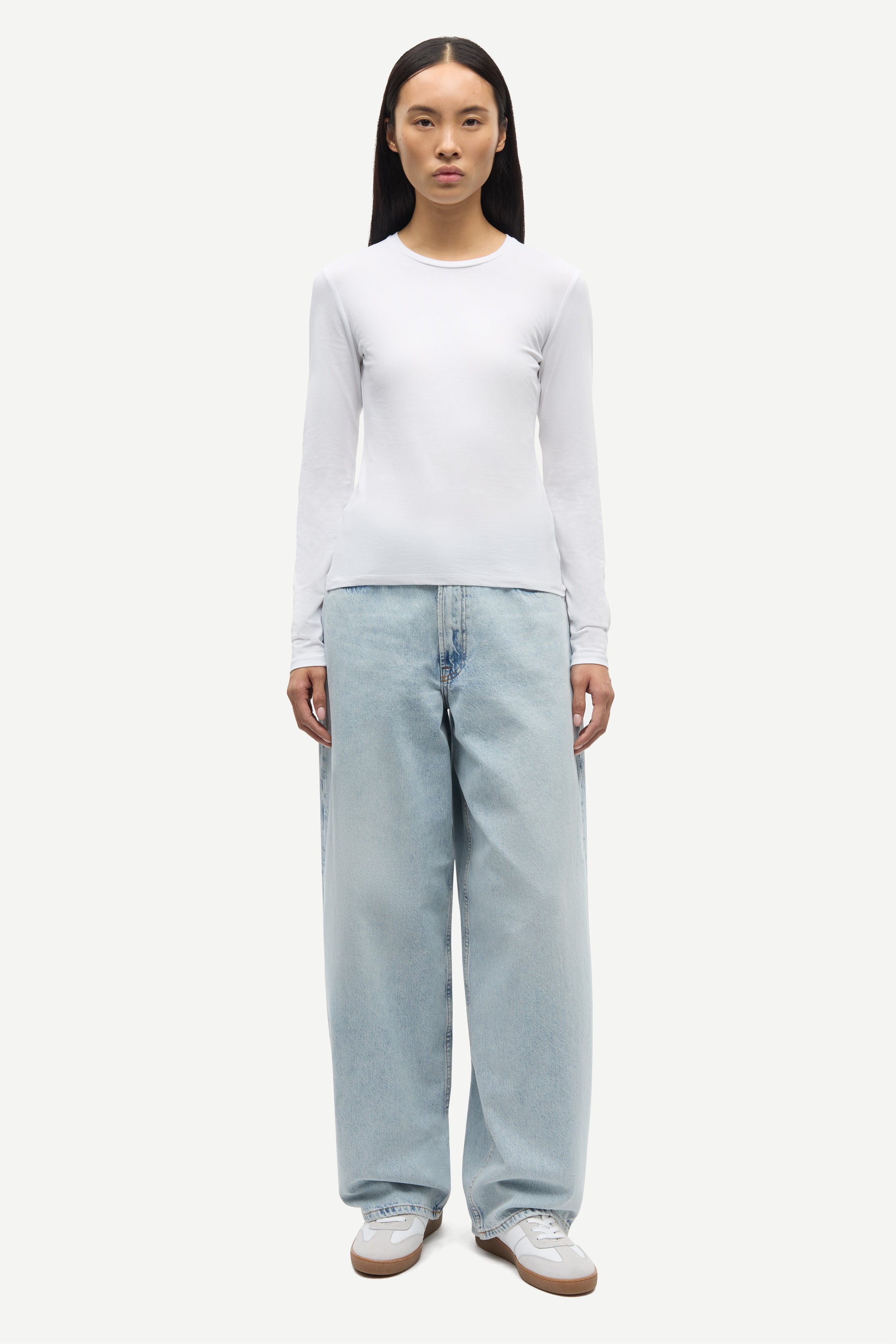 Person wearing white long sleeve tee  with blue jeans from Samsoe Samsoe