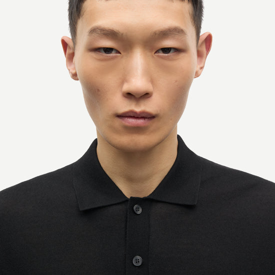 Man wearing a black polo shirt against a white background from Samsoe Samsoe