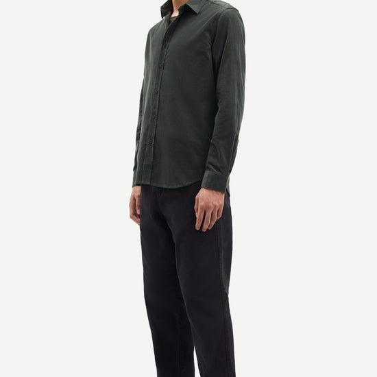 Man wearing a dark green cord shirt and black pants on a white background from Samsoe Samsoe