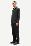 Man wearing a dark green cord shirt and black pants on a white background from Samsoe Samsoe