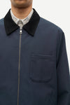 Navy blue jacket with black collar and plaid shirt underneath on a white background from Samsoe Samsoe