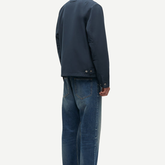 Man wearing a dark jacket and blue jeans on a white background from Samsoe Samsoe
