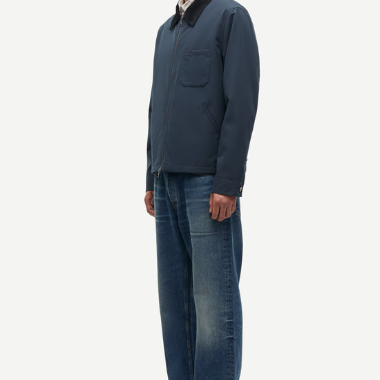 Man wearing a blue jacket and jeans on a white background
