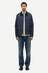 Man wearing a navy jacket, light shirt, and jeans on a white background from Samsoe Samsoe