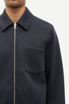 Navy blue jacket with a zipper and pocket on a white background