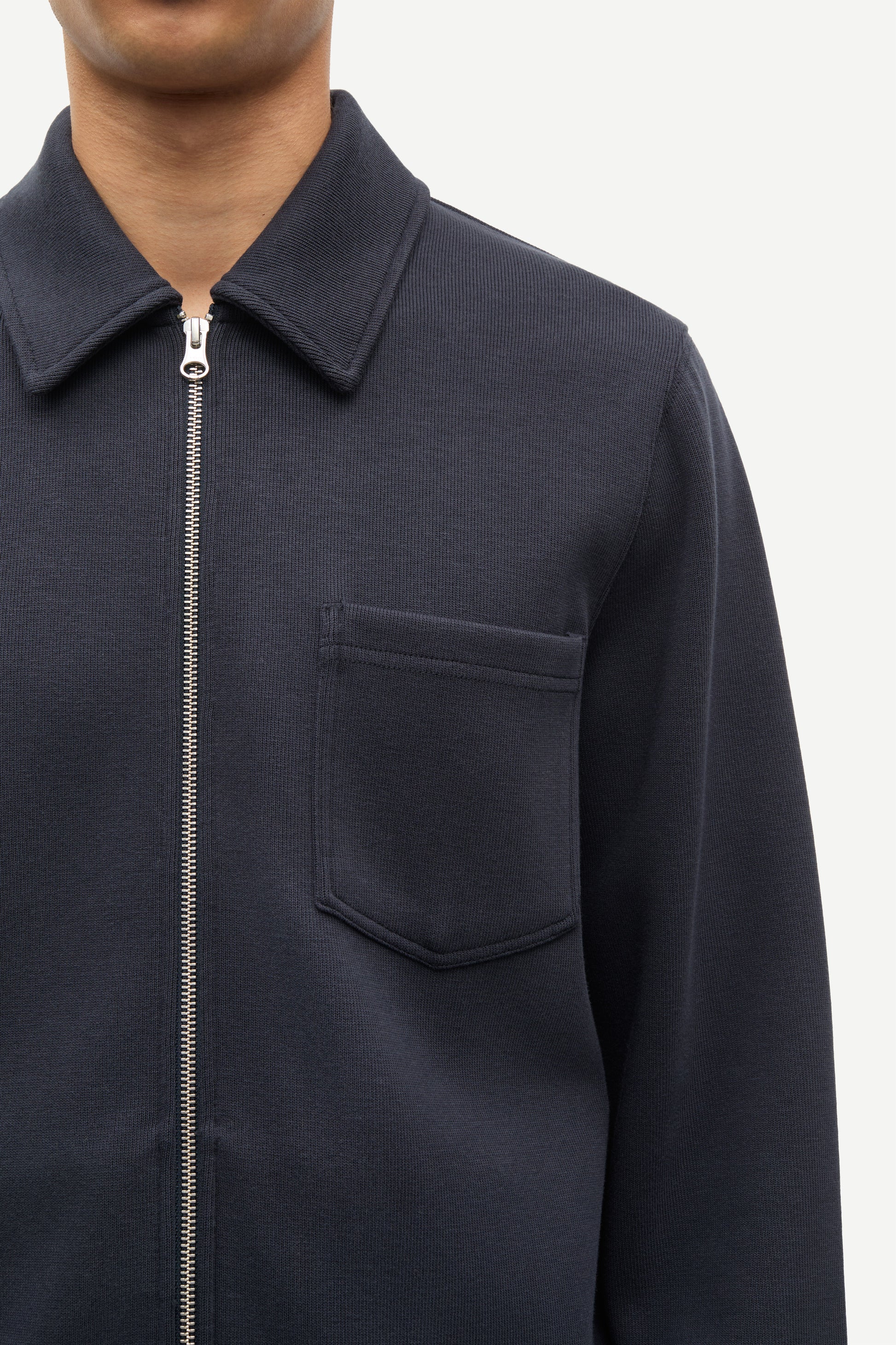 Navy blue jacket with a zipper and pocket on a white background